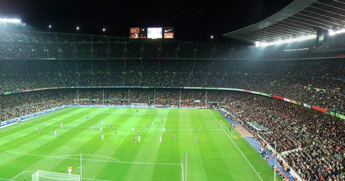 Pronósticos de hoy: panorámica del Camp Nou lleno durante un partido nocturno en Barcelona